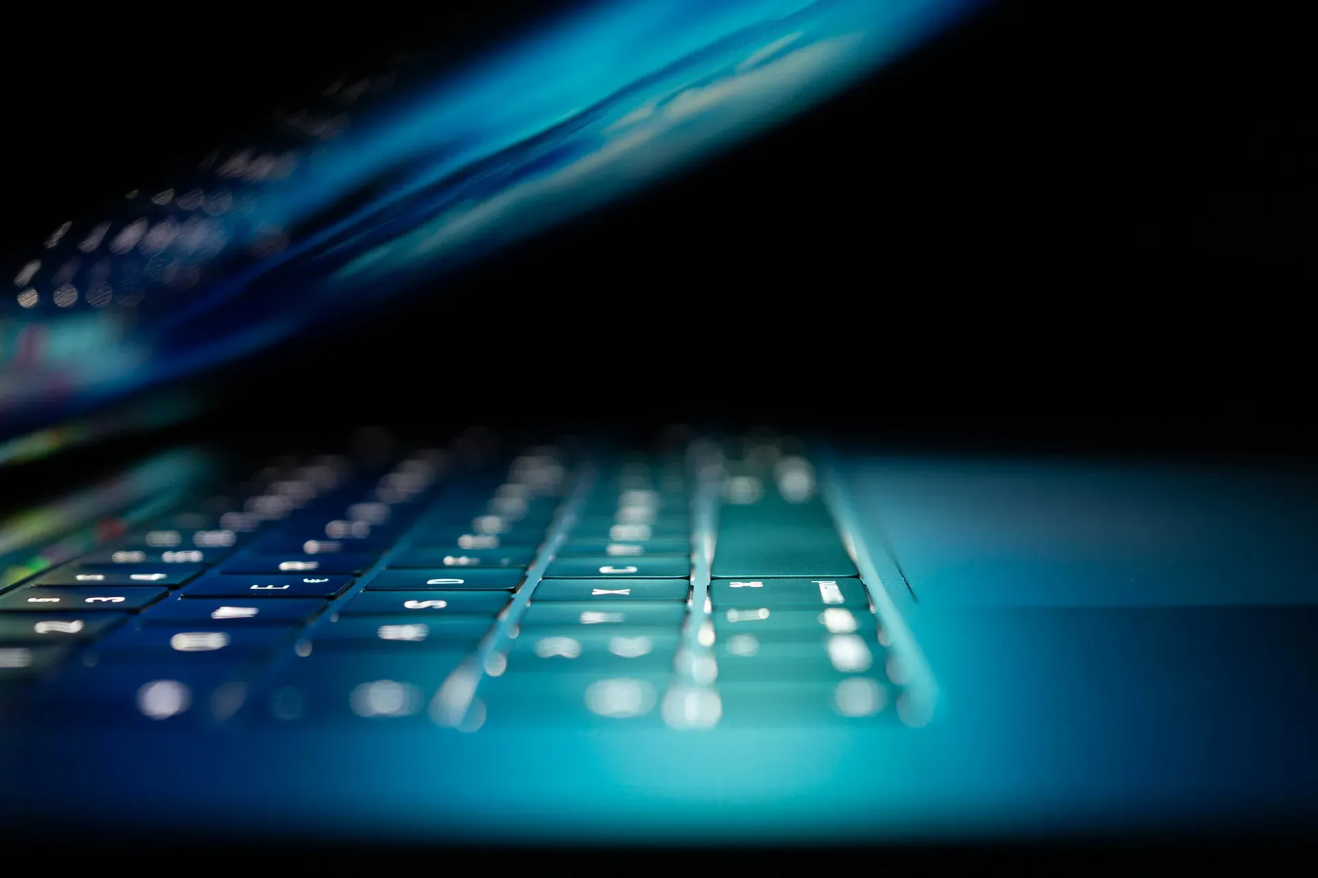 Laptop keyboard glowing in a dark room