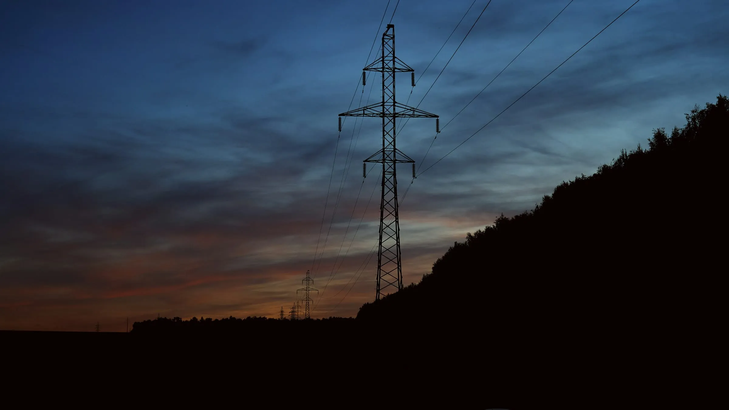 Electricity pylon silhouetted against the evening sky