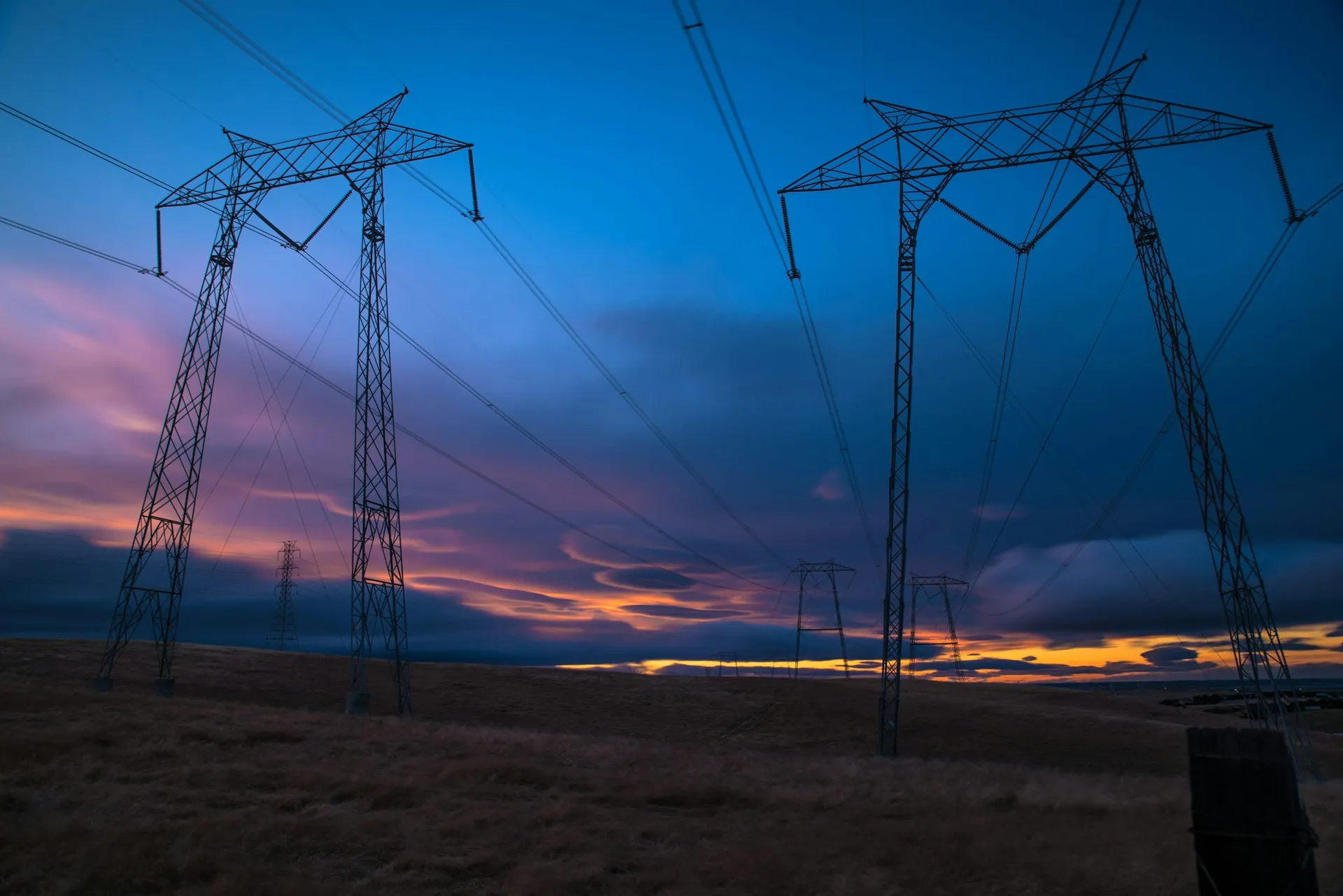 High-voltage transmission pylons against a dusk sky