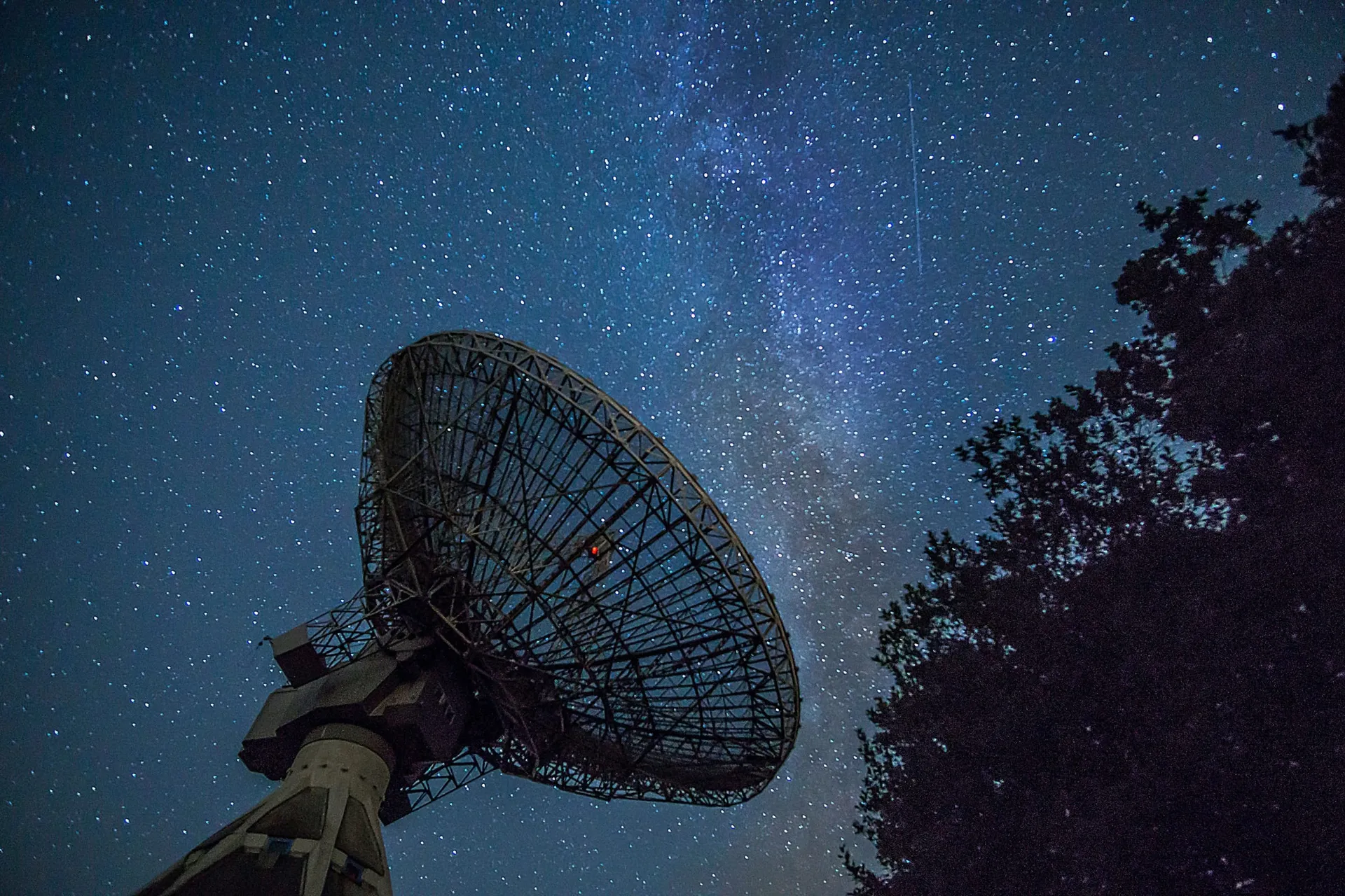 Large parabolic antenna under a starry night sky